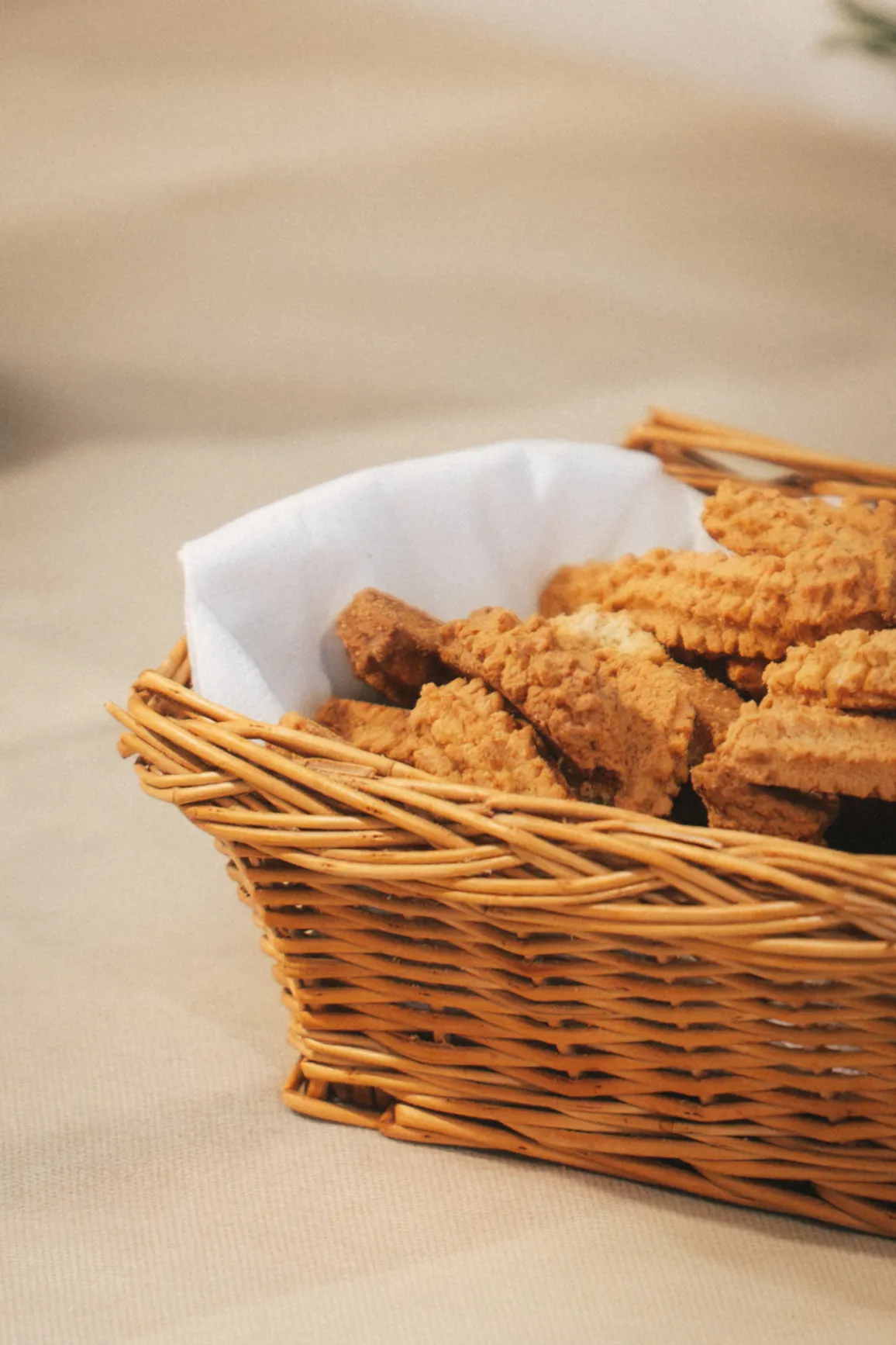 Cestino di vimini foderato di carta, colmo di biscotti fatti in casa