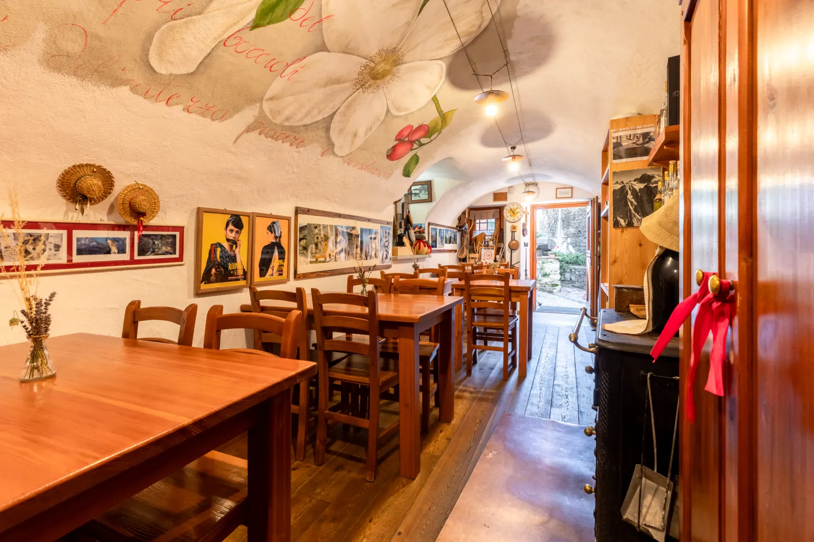 La sala a volta della locanda, con il fiore dipinto sul soffitto e la stufa in ghisa